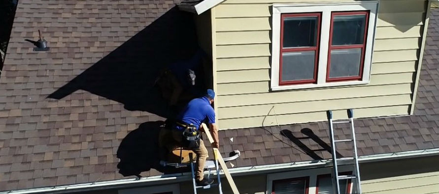 Superstorm Roofing Employee on Roofing doing a roof evaluation