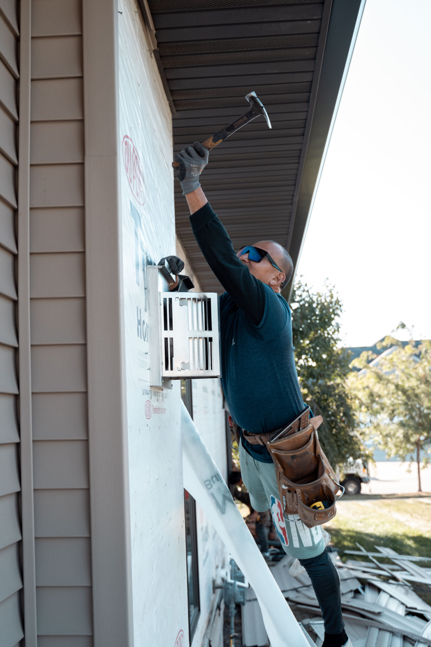 Superstorm employee installing siding